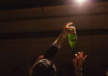 Bottle handed in a cellar-like space.