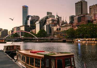 River in Melbourne, Australia with boats in front and buildings in the background.