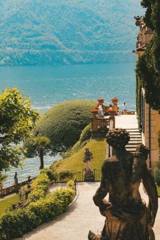 Side view of villa in lake como with statue .