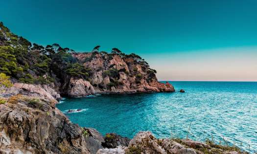 Photo of marbella sea with rocky surroundings.