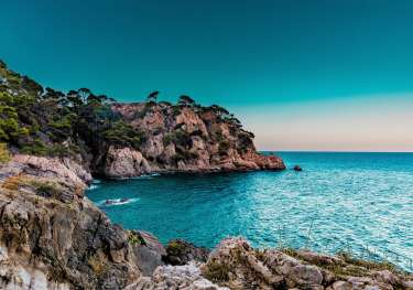 Photo of marbella sea with rocky surroundings.