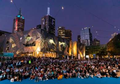 Crowd of people sitting in federation square on Australian Open Men's Final Night.