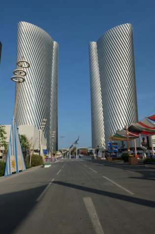 Large metal buildings on either side of a road.