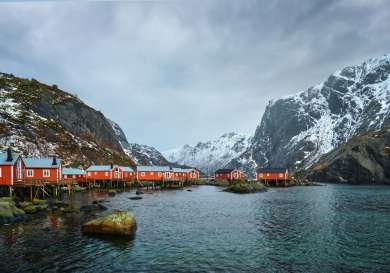 Red houses on stilts in norwegian fjords.