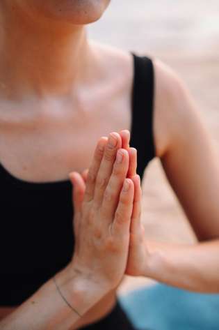 Person meditating with palms touching.