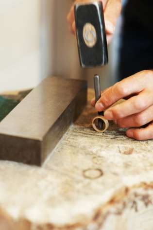 Person making ring in workshop.