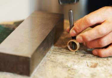 Person making ring in workshop.