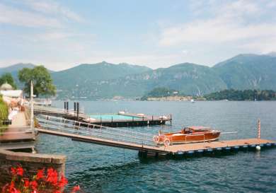 At Lake Como: a dock and boat, as well as a pool in the background.