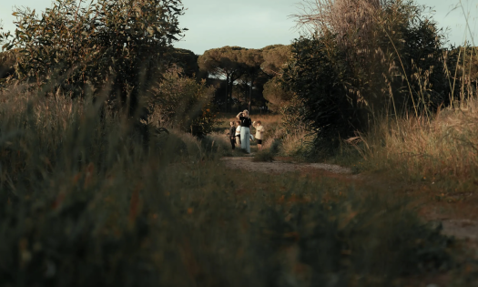 Woman and children walking on wooded path.