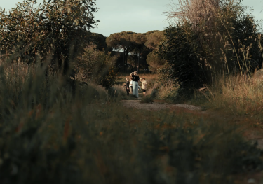 Woman and children walking on wooded path.