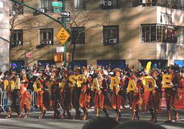 People in a line holding up yellow letter signs spelling out 