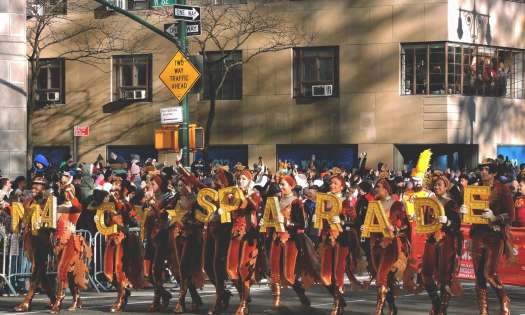 People in a line holding up yellow letter signs spelling out 