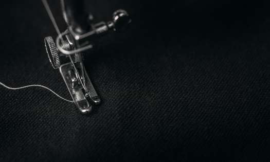 Sewing machine stitching on black fabric.