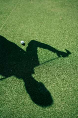 Shadow of golfer with golf club.