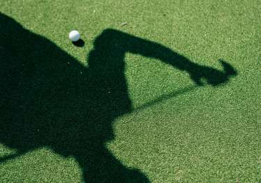 Shadow of golfer with golf club.