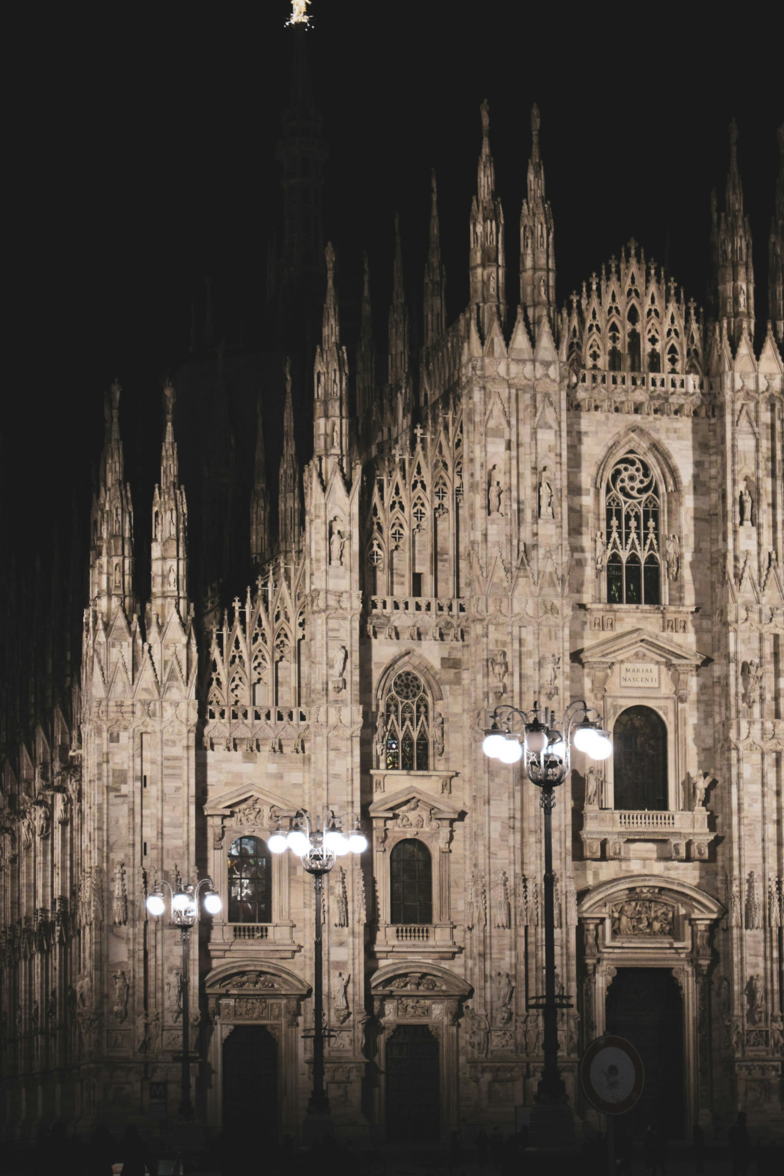 Duomo Catherdral in Milan at night with street lights in front
