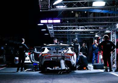 Race car at a pit stop at night.