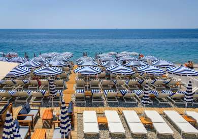 Beach day beds with striped parasols .