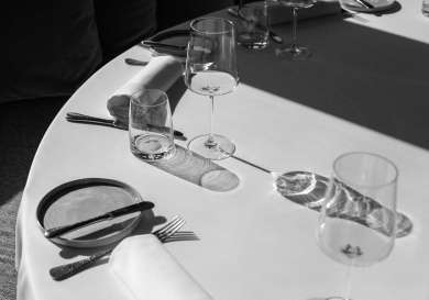 Table setting with wine glasses and plates.
