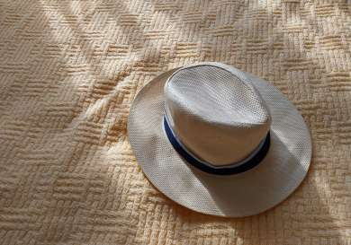 Straw hat on peach blanket.