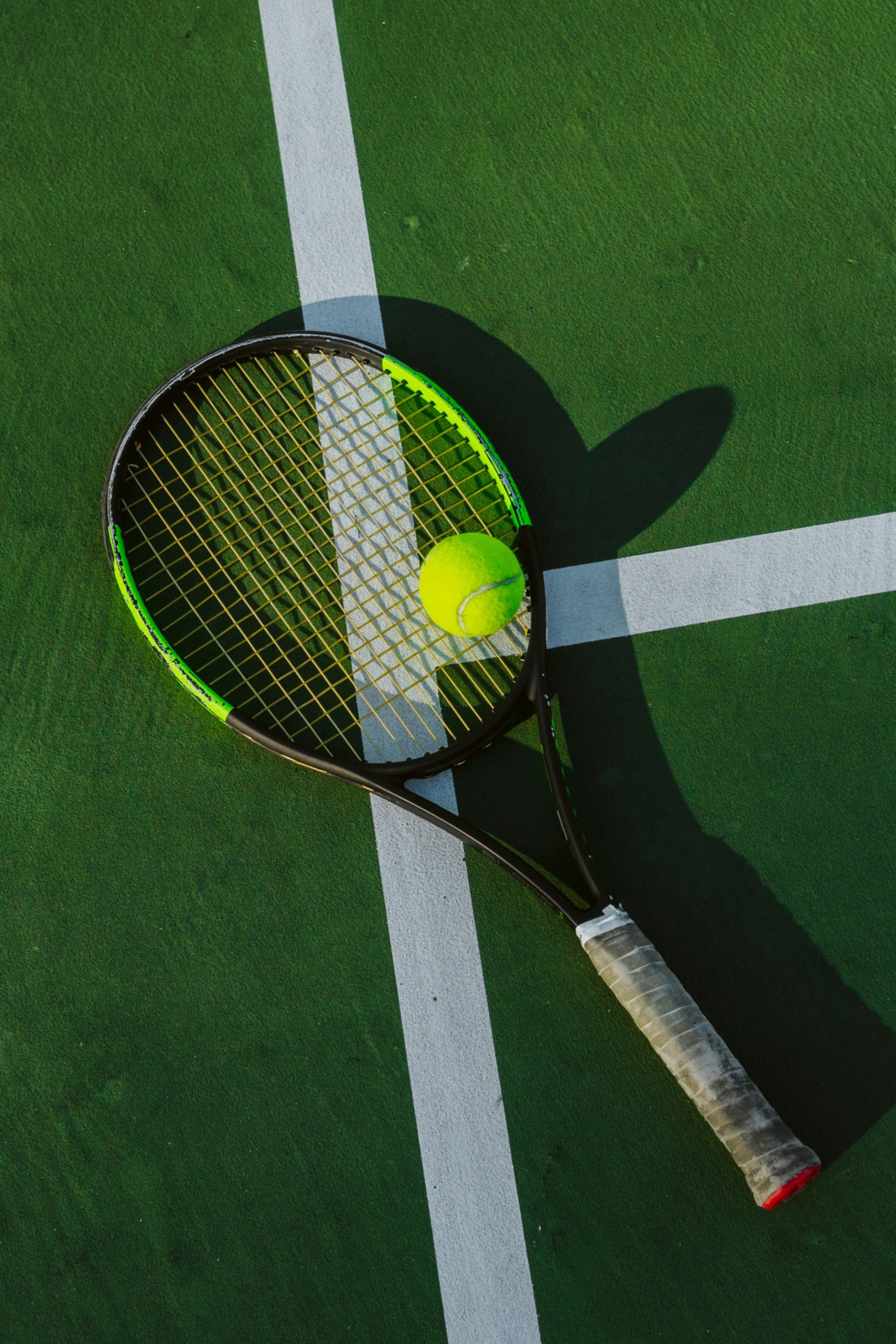 tennis racket on green court