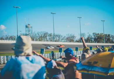 People watching a car race at the Daytona International Speedway.