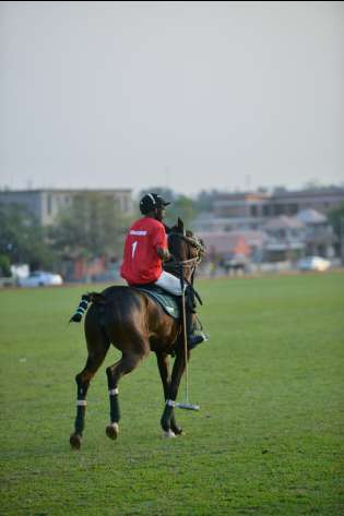 Men riding horse playing polo.