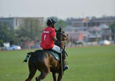 Men riding horse playing polo.