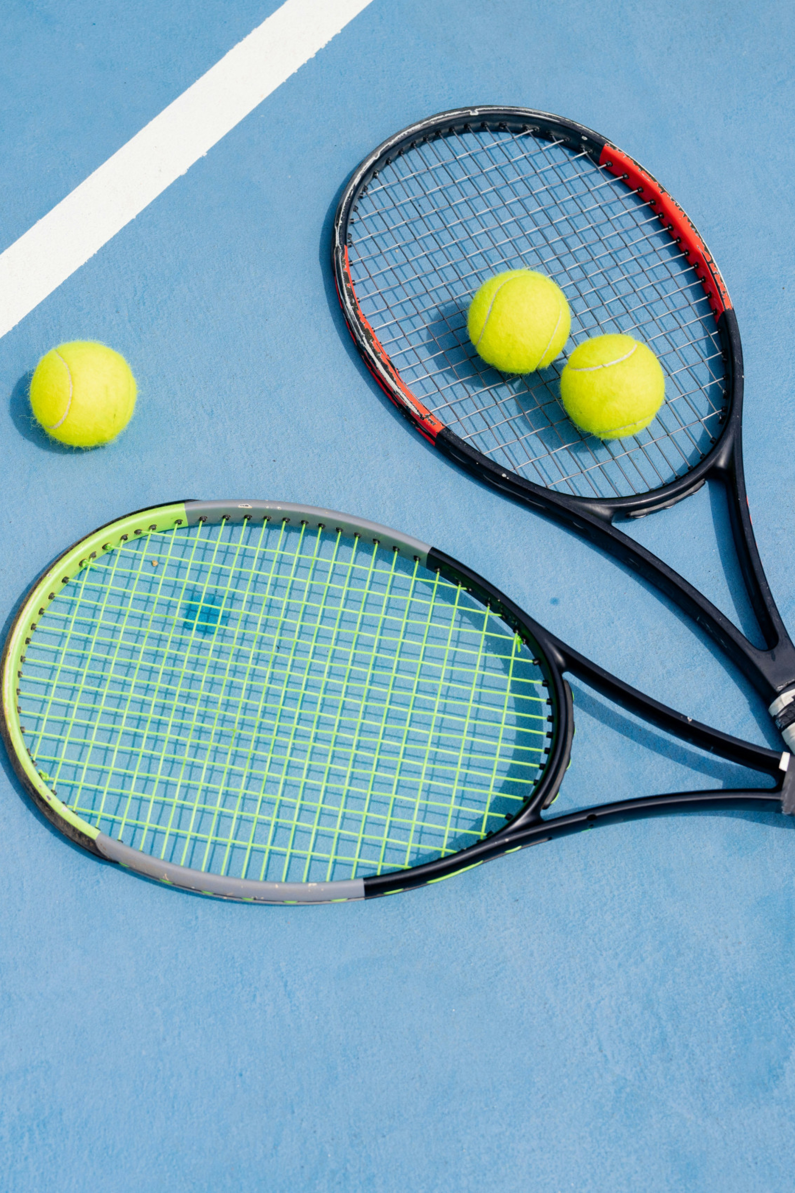 two crossed tennis rackets on blue tennis court