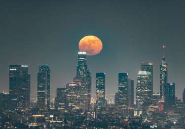 Las Angeles skyline at night with a large and beautiful moon.