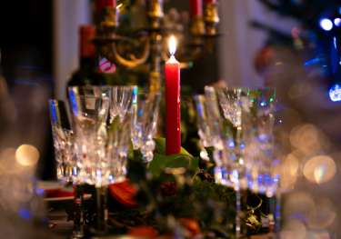 Table with champagne glasses and red candles on it.