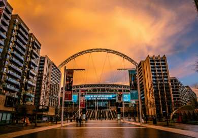 Outside view of wembley stadium at sunset .