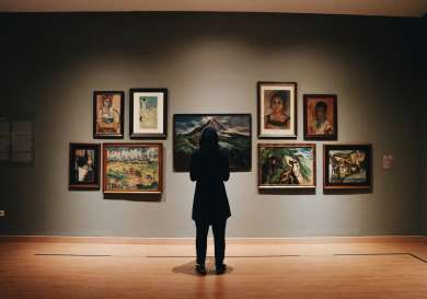 Person standing in front of an art gallery wall.