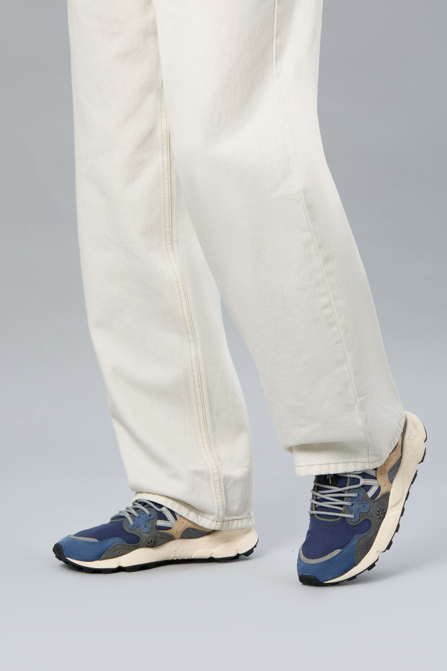 model wearing blue pair of trainers