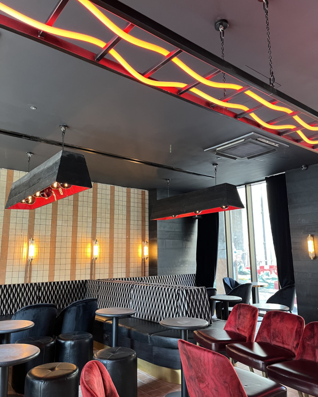 hotel gotham bar area with suspended ladder and black and red chairs