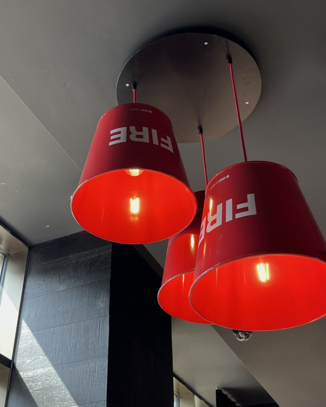 trio of ceiling lamps with red fire buckets as lampshades