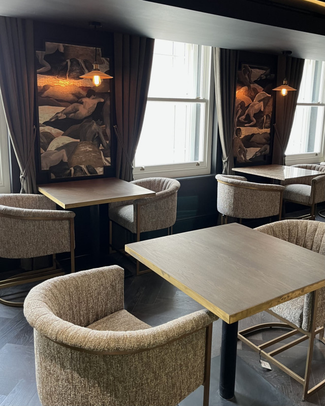 hotel gotham dining area with boucle chairs and light wood tables
