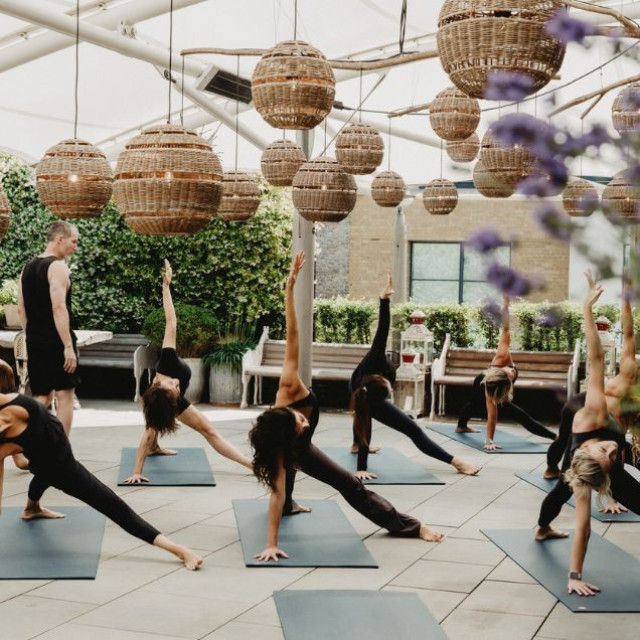 people doing yoga on hotel rooftop