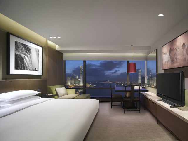 king bed suite at hotel with city skyline views