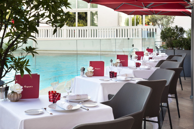 outdoor seating at hotel restaurant with red awnings 