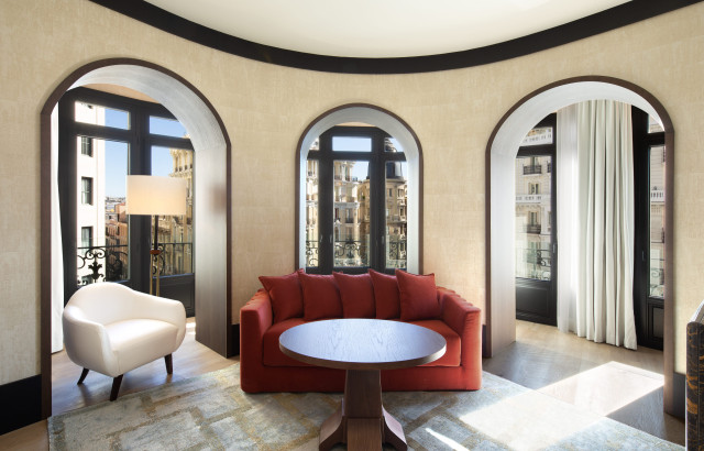 hotel lounge area with red sofa and cream chair