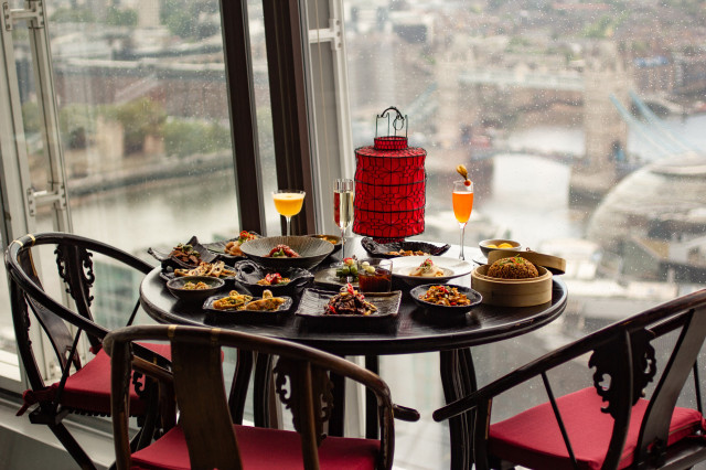 A table is set with various Asian dishes and drinks, featuring a red lantern centerpiece