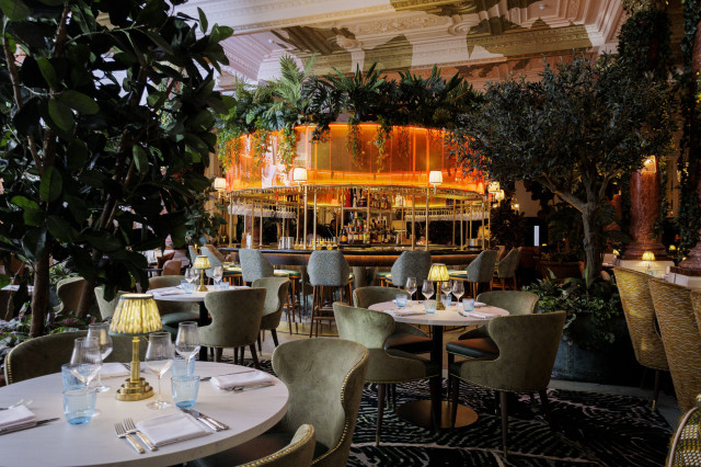 round tables in large restaurant with trees