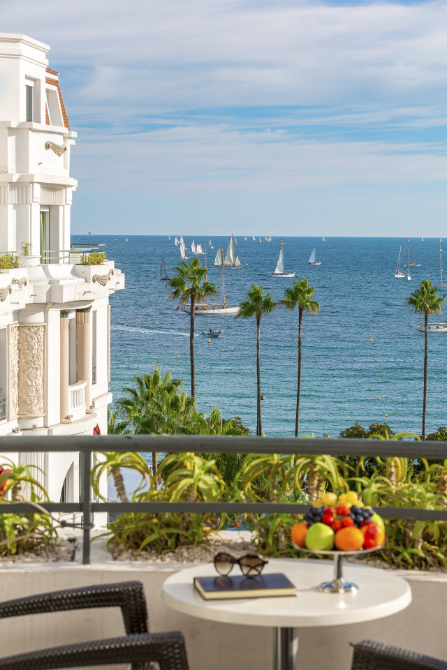 sea view from hotel balcony with fruit on small round table 