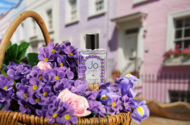 Jo Loves fragrance in basket of purple flowers 