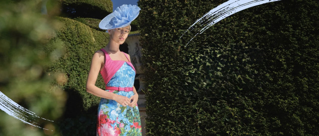 model wearing blue and pink floral dress and pastel blue hat