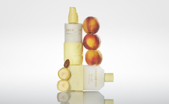 body glaze in butter yellow bottle with peaches and slices of fruit