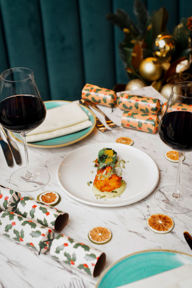 restaurant table with festive menu, wine and crackers
