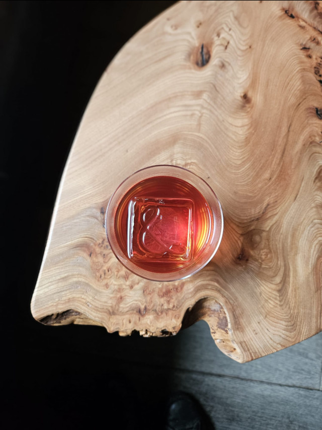 aerial view of prune negroni cocktail on organic wooden table