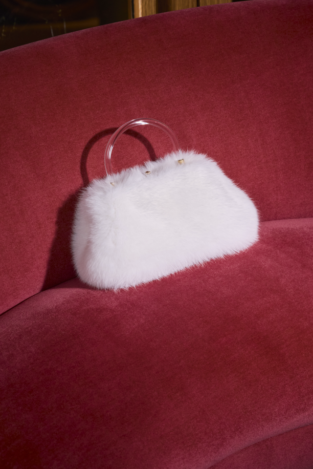 white fluffy bag on crimson velvet sofa 